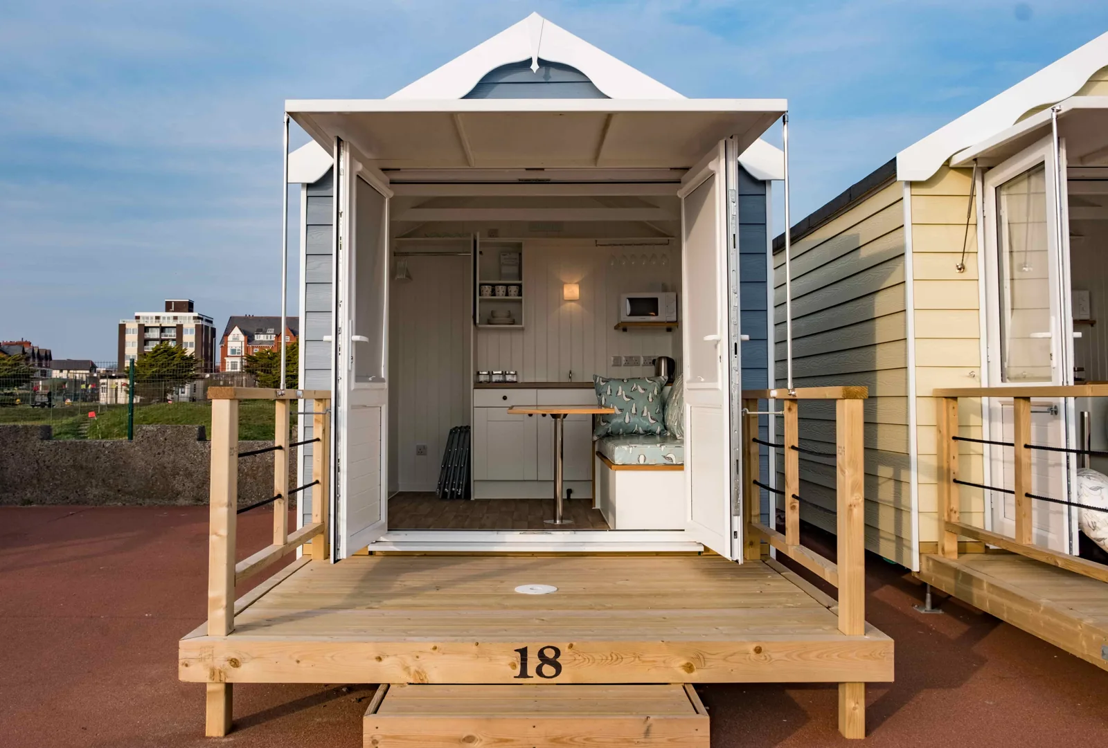 Open beach hut showing its kitchenette and seating