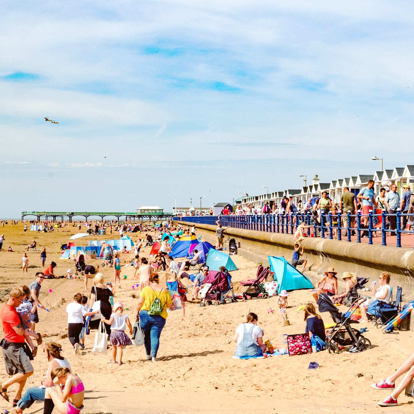 Families enjoying the beach with the Beach Huts along the promenade