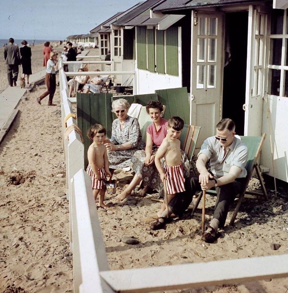 Generations of a family outside the green beach huts