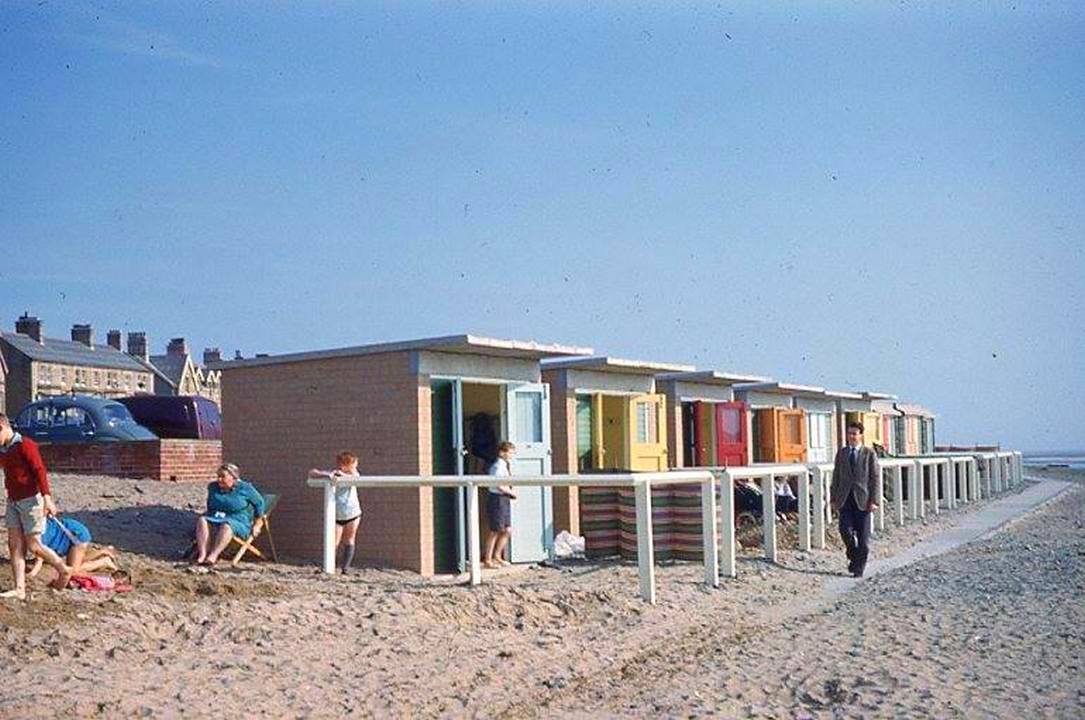 Visitors spending a day beside the beach huts